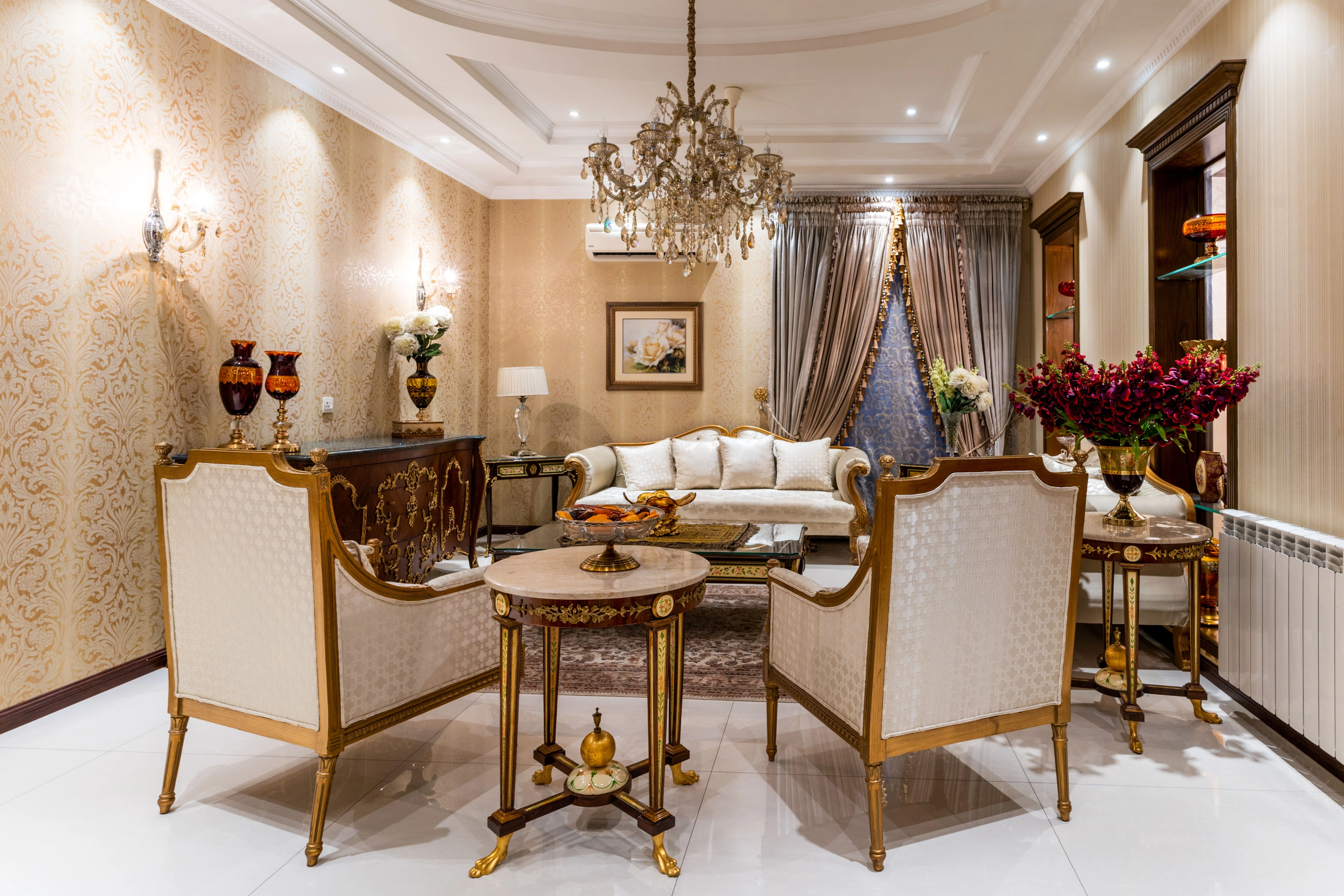 Warm ornamental wallpaper and collected art in a refined sitting area